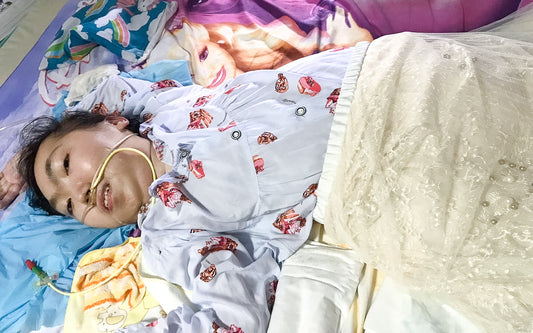 A mid-shot of Vivian lying on her bed with purple Barbie bed sheets. She is wearing a purplish-blue pyjama top and the readapted cream coloured skirt.